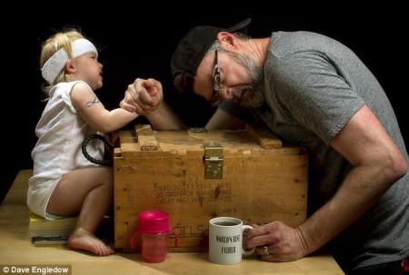 toddler girl arm-wrestling dad